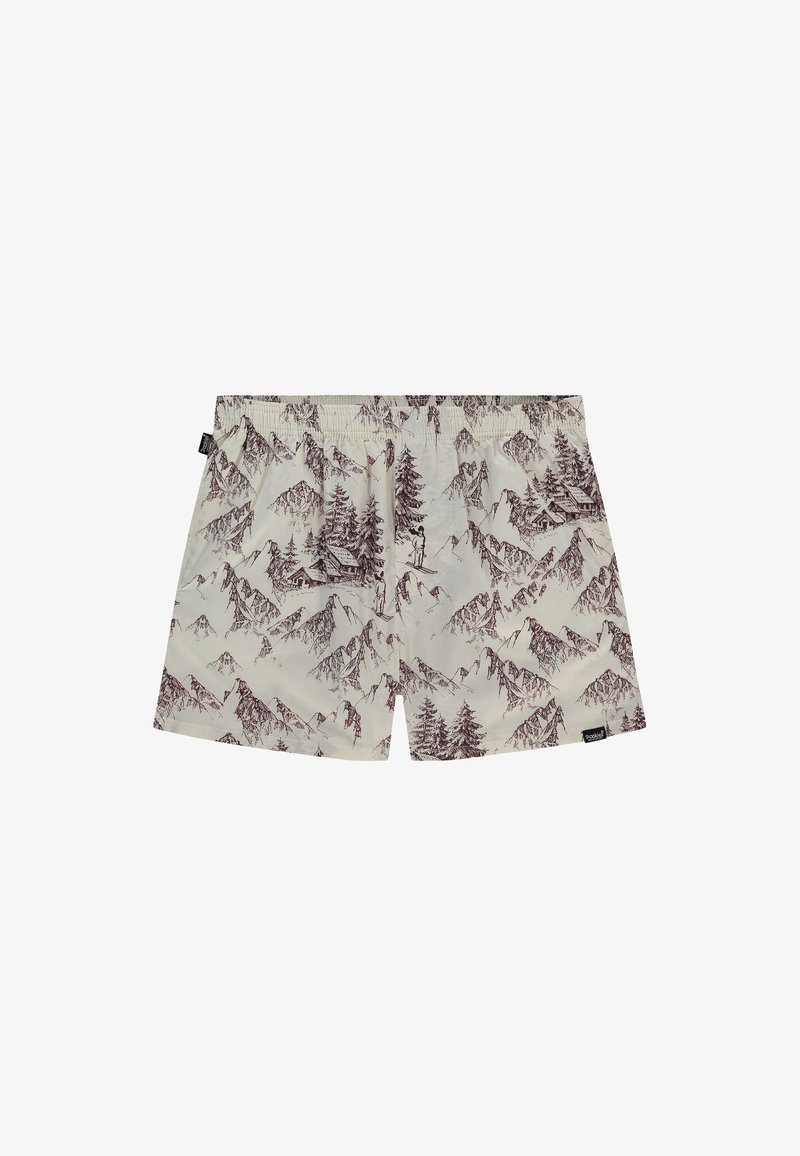 Shorts beige avec motifs marron de montagnes et de pins, comprenant un petit skieur et une cabane, taille élastique et étiquette latérale.