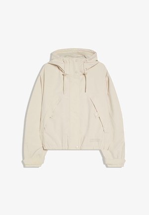 Világos bézs kapucnis dzseki elülső cipzárral és patentgombokkal, állítható húzózsinórokkal a kapucnin, valamint elasztikus mandzsettákkal és szegéllyel.