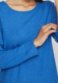 Maglione blu lavorato a maglia con scollatura rotonda e polsini a costine. Il tessuto ha un aspetto texture e una finitura morbida, evidenziando il suo calore.
