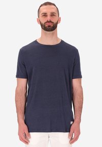 T-shirt a maniche corte di colore blu navy realizzato in tessuto leggero, con collo rotondo e una piccola etichetta con logo sul bordo.