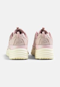 Zapatillas deportivas rosas con un upper texturizado, suela acolchada y detalle del logo en la parte trasera. Presenta un tira de agarre y un diseño perforado para mayor transpirabilidad.