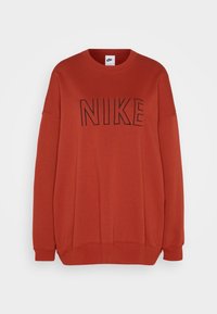 Červená mikina s černým logem "NIKE", kulatý výstřih, volný střih, žebrované manžety a lem, vyrobená z měkké bavlněné směsi, hladká textura.