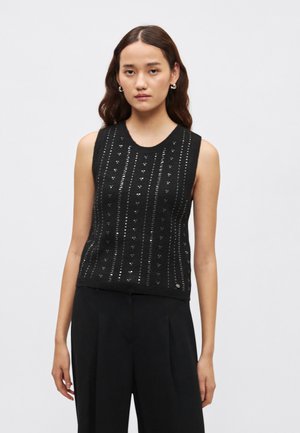 Melna bezroku trikotāžas virskrekls ar fakturētu rakstu sudraba akcentiem un apaļu kakla izgriezumu. Izstrādāts ar pieguļošu siluetu.