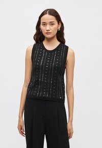Črn top brez rokavov iz pletenine s teksturiranim vzorcem in srebrnimi poudarki ter okroglim izrezom. Oblikovan z oprijetim krojem.
