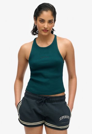 Débardeur vert en maille avec col rond et logo, associé à un short de sport gris foncé avec des rayures blanches et des détails de logo.