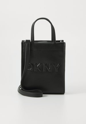 Schwarze rechteckige Ledertasche mit eingeprägtem DKNY-Logo, doppelten Griffen und einem langen abnehmbaren Schulterriemen vor einfarbigem Hintergrund.