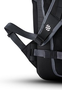 Mochila de tela negra con acentos grises, que cuenta con correas ajustables, hebillas laterales y paneles texturizados para mayor durabilidad y soporte.