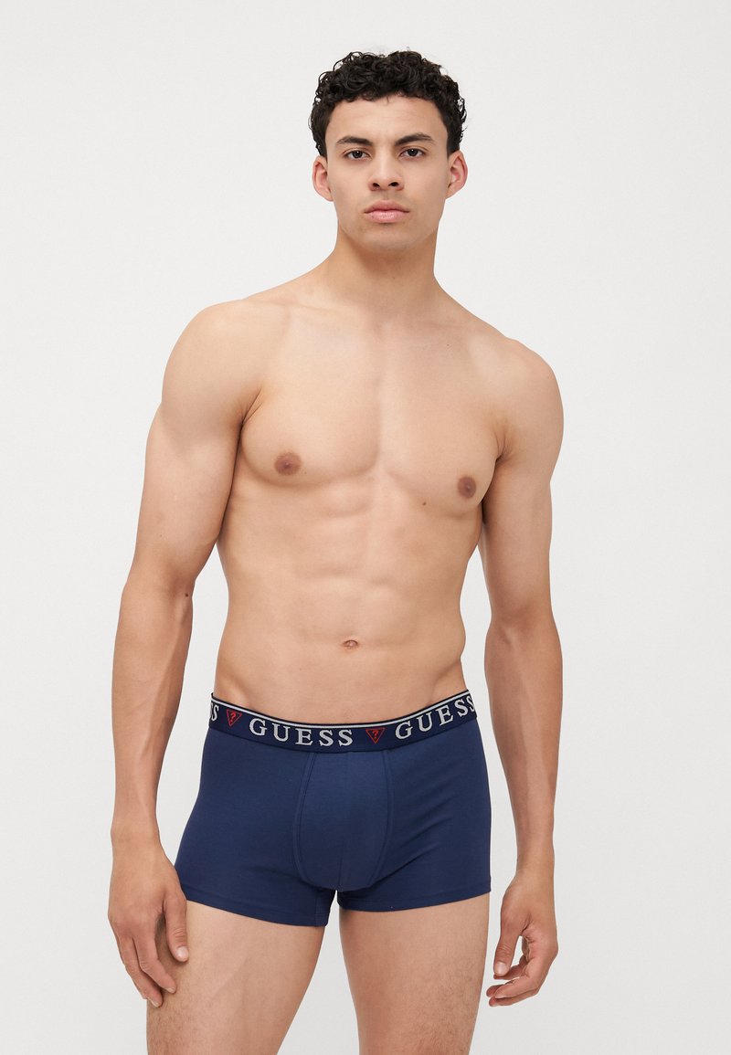 Boxeri scurți de culoare albastru marin, cu un talie elastică branduită ce prezintă logo-ul "GUESS" în culori contrastante. Amestec de bumbac cu textură netedă.
