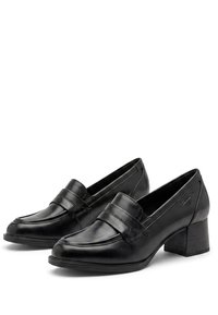 Μαύρα δερμάτινα γυναικεία loafers με χοντρό τακούνι και λουράκι στο πάνω μέρος, εμφανίζονται δίπλα-δίπλα σε λευκό φόντο.