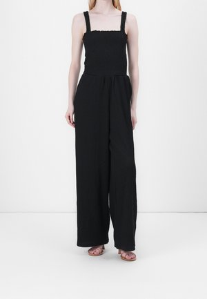 Czarny kombinezon z marszczonym przodem, kwadratowym dekoltem i szerokimi nogawkami. Wykonany z fakturowanej tkaniny i z grubymi ramiączkami.