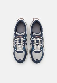Navy and gray athletic shoes with mesh upper, white laces, and logo. Features rounded toe and cushioned sole for support.