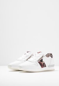 Sneakers bianchi con un pannello in stampa serpente testurizzata, lacci piatti, cerniere laterali e un accento argento sul tallone, realizzati in materiali sintetici.