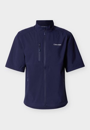 Navy blue short-sleeve jacket with front zipper, zippered chest and side pockets, and "Calvin Klein" logo on left chest.