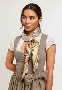 Silk scarf featuring intricate gray and gold patterns, with a smooth texture and contrasting orange border, tied around the neck.