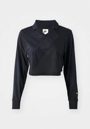 Polo noir cropped à manches longues avec col en V, présentant un design de couture diagonale, une texture lisse et un logo Nike sur la manche.