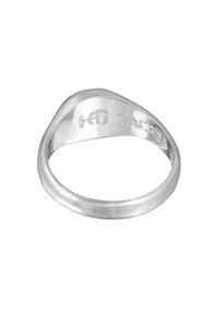 Sidabrinis žiedas su lygiu, suapvalintu dizainu. Yra poliruota išorė ir tekstūruota vidus, su įraiža "HB SACRED" viduje.