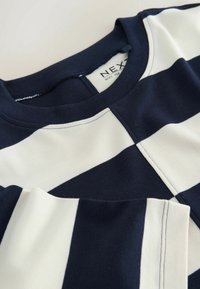 Marineblauw-wit horizontaal gestreept shirt met lange mouwen, ronde hals en zichtbaar merklabel aan de binnenkant van de kraag.