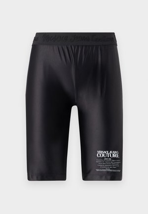 Sorte shorts laget av glatt stoff, med en preget midje og hvit trykt tekst på venstre ben.