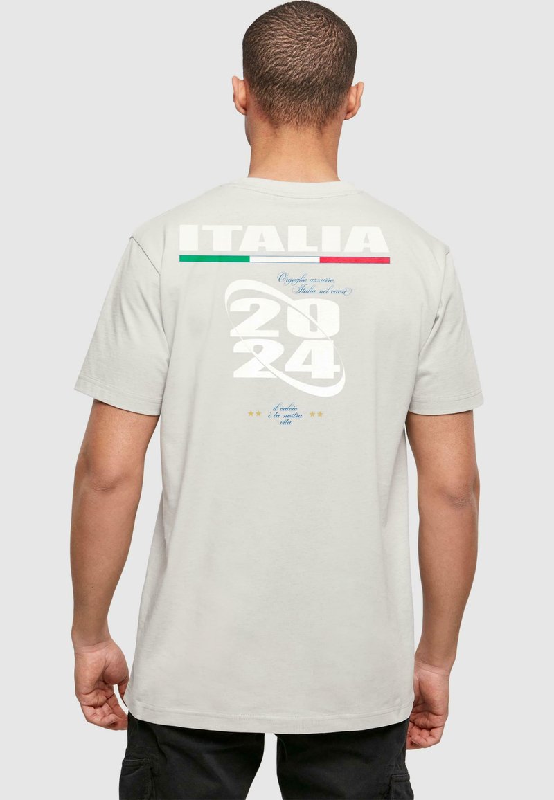 T-shirt in cotone grigio chiaro con il testo "ITALIA", accenti verde e rosso, e "2024" in bianco in grassetto. Dettagli stampati includono stelle e frasi.