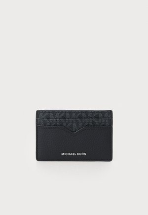 Porte-cartes en cuir noir avec une section supérieure texturée et un design en chevron. Présente le logo "MICHAEL KORS" en relief en bas.