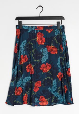 Falda floral en tela azul oscuro con flores rojas y verde azulado, con patrones de hojas. Diseño plisado, colgada de un gancho de plástico negro.