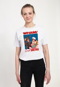 Bílé bavlněné tričko s grafikou dvou postav, jedna s parohy a druhá ve slavnostním oblečení, s nápisem „WHAM! Last Christmas.“