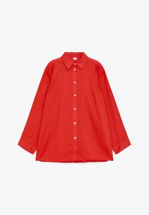 Rød skjorte med lange ærmer, knapper og spids krave, lagt fladt på en hvid baggrund.