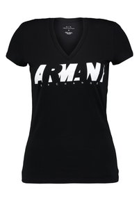 Černé upnuté tričko s výstřihem do V se velkým bílým nápisem "ARMANI EXCHANGE" na hrudi.