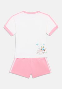 Fehér pamut póló rózsaszín szegéllyel, rajta játékos grafika karakterekkel és pillangókkal; rózsaszín rövidnadrággal párosítva.