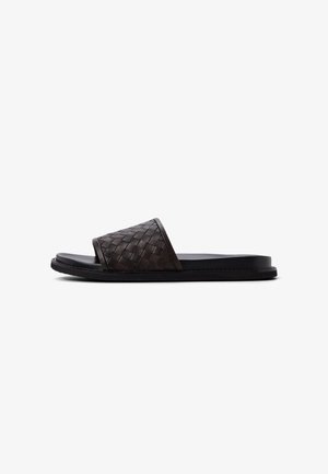 Bruine gevlochten leren slippers met een vlakke zwarte zool, voorzien van een open teen en een brede band over de bovenkant voor een stevige pasvorm.