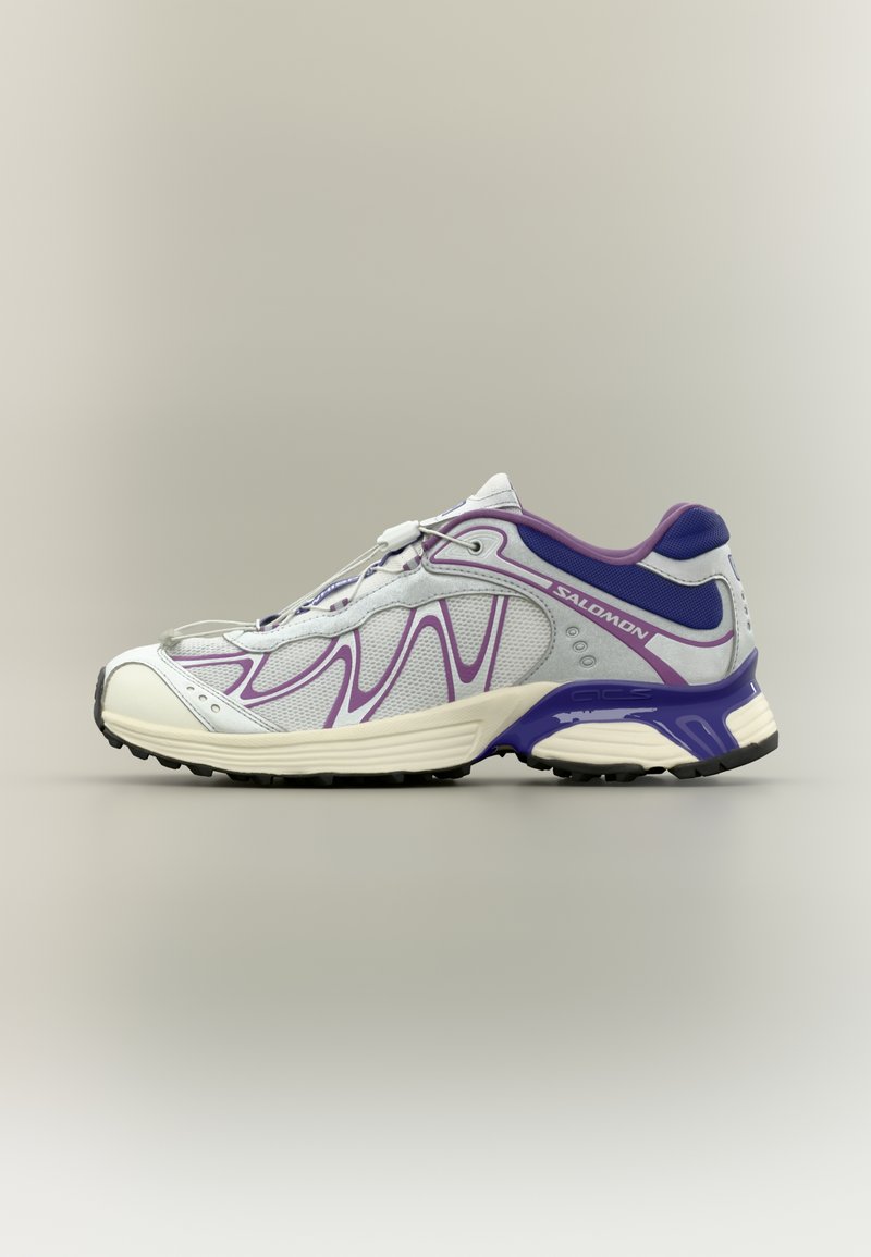 Running shoe featuring a white mesh upper with purple accents, a rounded toe, cushioned sole, and textured black rubber outsole.