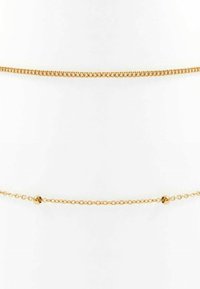 Goldkettchen-Halskette mit zwei unterschiedlichen Schichten: einer dickeren Panzerkette und einer zarten Kette mit sphärischen Akzenten. Glatte und glänzende Textur.