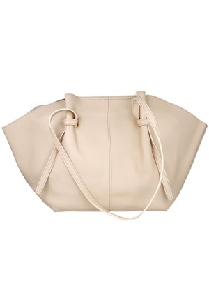 Bolso de mano de cuero beige con lados anchos y ligeramente acampanados y dos tirantes delgados que se sujetan cerca de los bordes superiores.