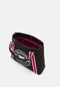 Svart canvas tote-väska med en stor rund logotyp med "LOVE MOSCHINO," röd och vit randig dekor och ett röd tyginrede.