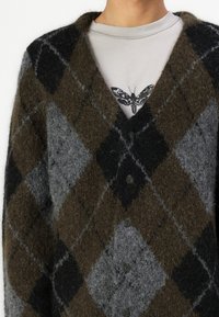 Cardigan in lana scura con un classico motivo a rombi in tonalità di marrone, grigio e nero. Il design include cinque bottoni e una texture morbida.