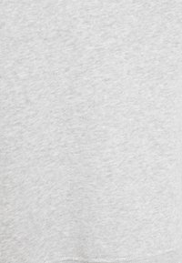 Tela suave de color gris claro liso con una sutil textura jaspeada y costuras visibles en el borde inferior.