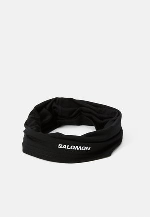 Must mustriba pehmeast kangast valmistatud musta värvi peaeband, mille ühel küljel on valge "SALOMON" logo ja torukujuline disain mitmekesise kandmise jaoks.