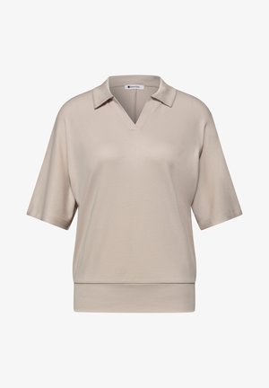 Beige lyhythihainen poolopaita V-kaula-aukkolla ja väljävartisella istuvuudella, jossa on kaulus ja leveä helma alaosassa.