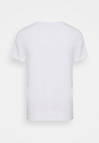 Vit bomullströja med korta ärmar, rund halsringning och mjuk textur. Inga synliga mönster eller grafik på baksidan.