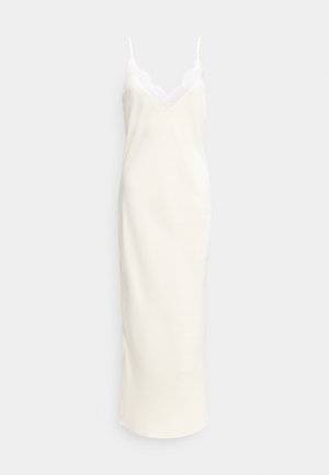 Μακρύ κρεμ φόρεμα με λεπτές ρυθμιζόμενες τιράντες και δαντελένιο τελείωμα κατά μήκος του V-λαιμού.