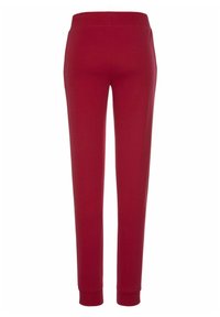 Rote Sweatpants mit glatter Textur, elastischem Bund und schmal zulaufendem Beinanschnitt. Keine Taschen oder zusätzlichen Verzierungen sichtbar.