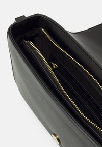 Borsa a tracolla in pelle nera con cerniere e finiture dorate. Presenta più scomparti e un rivestimento interno texturizzato per una migliore organizzazione.
