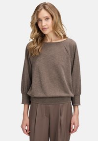 Bruine, gestructureerde, lichtgewicht trui met een ronde hals, raglanmouwen en elastische manchetten, gecombineerd met bijpassende bruine broek.