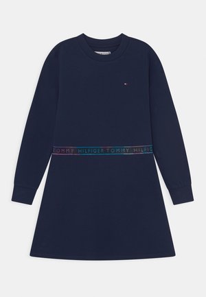 Granatowa sukienka dresowa z długim rękawem, okrągłym dekoltem oraz elastycznym pasem z wielokolorowym tekstem logo. Miękka, przyjemna w dotyku tkanina.