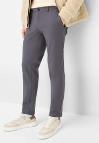 Grijze, op maat gemaakte broek van rekbare stof, met een knoopsluiting, steekzakken aan de voorkant en een slanke pasvorm, gecombineerd met witte sneakers.