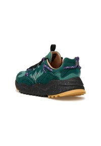 Sneaker verde e nero con accenti viola, suola spessa e maculata, tomaia testurizzata e linguetta e pull tab sul tallone, vista angolata dal retro.