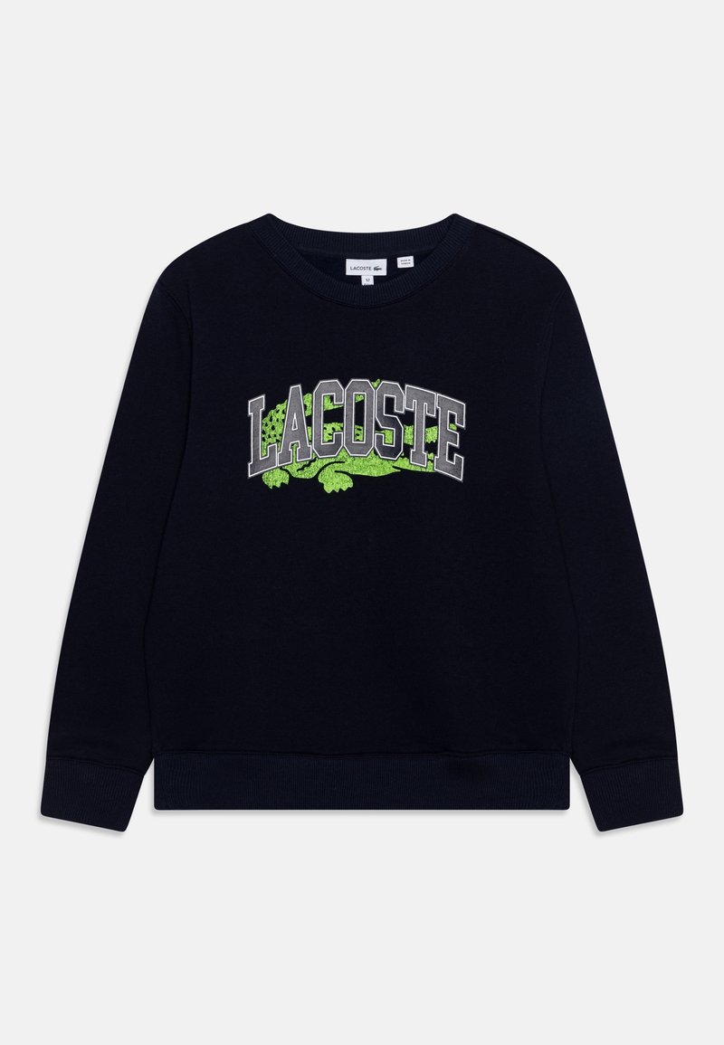 Sweat-shirt noir à manches longues avec col rond, texte "LACOSTE" et logo crocodile vert imprimés au centre devant.