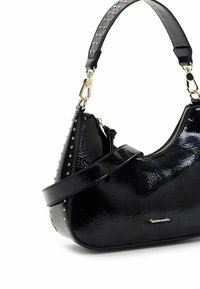 Melna lakādas somiņa ar izliektu formu, ar naglām rotātu siksnu un zelta krāsas rāvējslēdzēju. Kompakts dizains ar strukturētu formu.