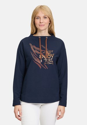 Navy sweatshirt with a relaxed fit, featuring a drawstring hood, textured accents, and bold printed text design in copper and orange hues.