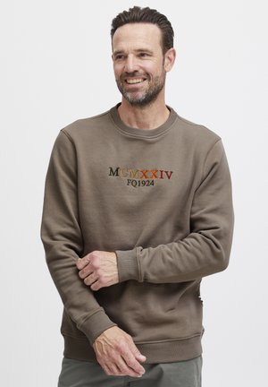 Bruine katoenen sweatshirt met ronde hals en geribde manchetten. Geborduurde tekst "MCMXXIV FQ1924" in verschillende kleuren op de voorkant.